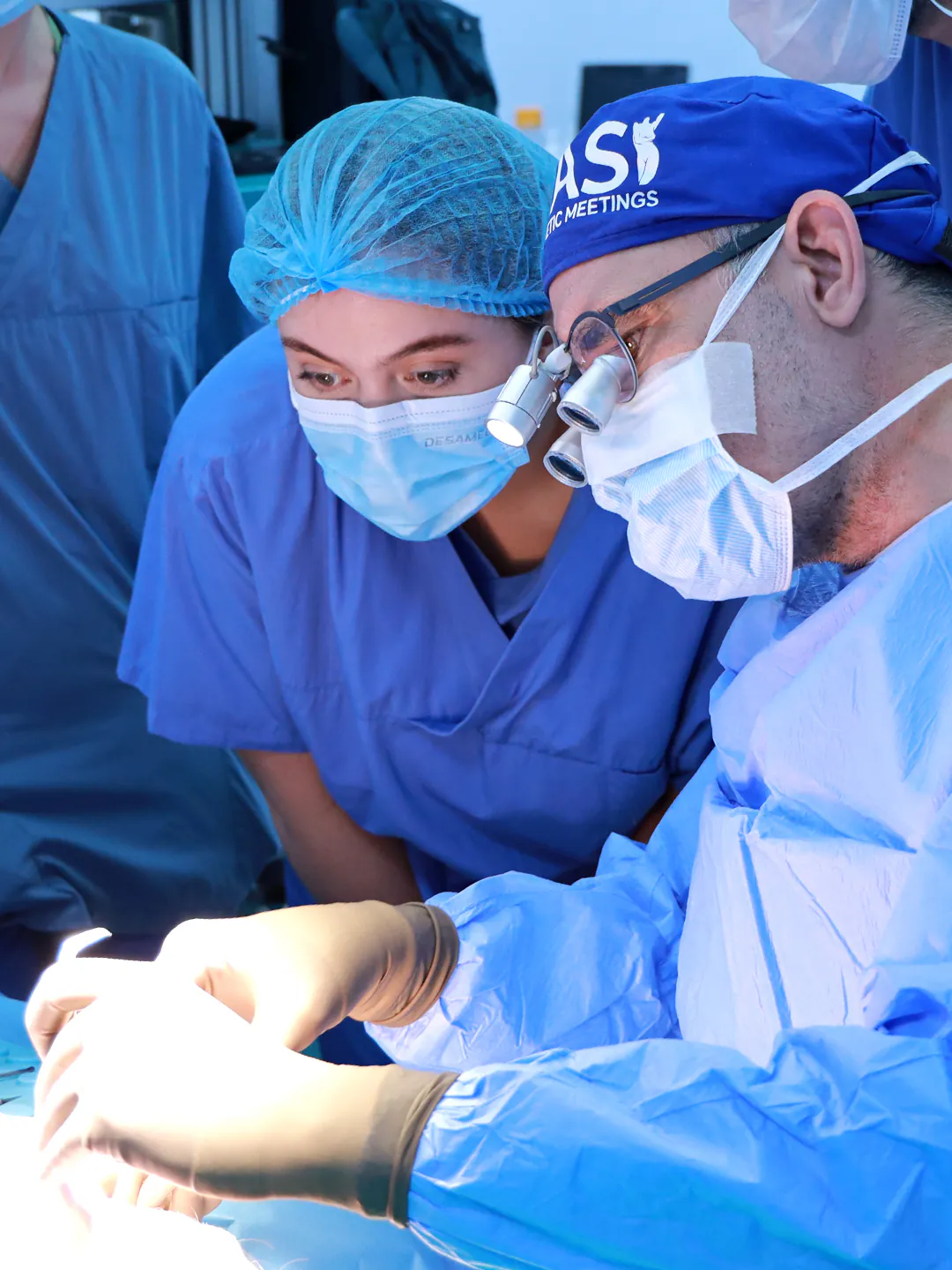Dr. Teoman Dogan and an assistant surgeon working with loupes at the operating field